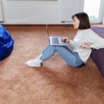 a1interested-woman-works-laptop-computer-sitting-floor-near-black-sofa-min_wp